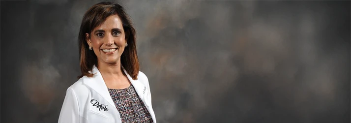 Dr. Usha Mantha posing for a professional photoshoot wearing a white coat